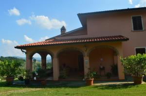 une maison avec une terrasse couverte ornée de plantes dans une cour dans l'établissement Agriturismo Le 3 Rose, à Antria