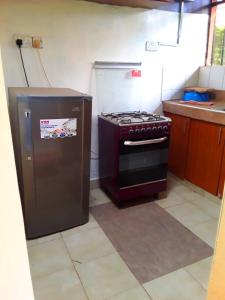 a kitchen with a stove and a refrigerator at New Kitisuru D in Nairobi