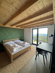 Schlafzimmer mit einem Bett, einem Tisch und einem Fenster in der Unterkunft Resort Javorníky in Makov