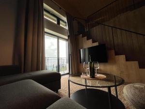 ein Wohnzimmer mit einem Sofa und einem Tisch mit Weingläsern in der Unterkunft Resort Javorníky in Makov