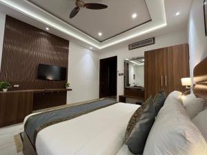 a bedroom with a bed and a flat screen tv at Hotel Kalawati Palace in Varanasi