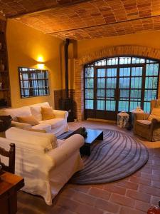 uma sala de estar com dois sofás brancos e uma mesa em CASCINA BELLAVISTA - Luxury Country Villa + Pool 