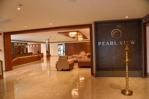 a hotel lobby with a pearl view sign on the wall at THE PEARL VIEW HOTEL in Mulappilangād