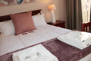 1 cama grande con 2 toallas encima en Accommodation at Potch Guesthouse, en Potchefstroom