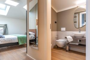 a bathroom with a sink and a toilet and a mirror at The Place - Only Self Check-in - No Reception in Trento