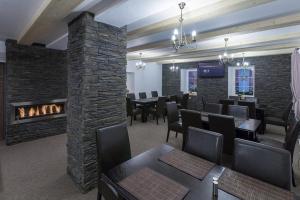 a dining room with a fireplace and tables and chairs at Penzion Bernard in Boží Dar