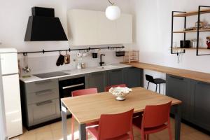 a kitchen with a wooden table and red chairs at La Casa nel Borgo in Montecastrilli
