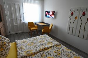 1 Schlafzimmer mit 2 Betten, einem Tisch und Stühlen in der Unterkunft Gästehaus zum See in Illmitz