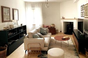 ein Wohnzimmer mit einem Sofa und einem Tisch in der Unterkunft La Casa nel Borgo in Montecastrilli