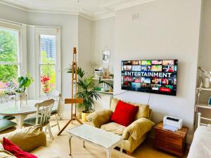 a living room with a couch and a table at Artist's Bright Hampstead Heath Village 2 bed in London