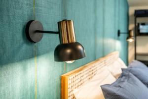 a black lamp hanging on a wall next to a bed at The Place - Only Self Check-in - No Reception in Trento