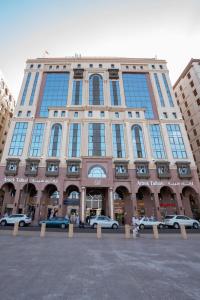 un grande edificio con auto parcheggiate di fronte di Araek Taiba Hotel a Medina