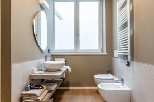 a bathroom with a sink and a toilet and a mirror at The Place - Only Self Check-in - No Reception in Trento