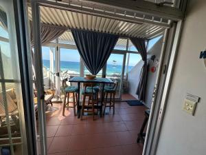 a dining room with a table and chairs and the ocean at Playa Del Mar 12 in Margate +13 photos
