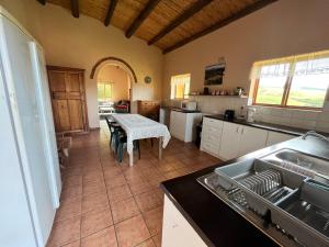 a kitchen with a table and a dining room at Iron River Farm Self Catering in Heidelberg