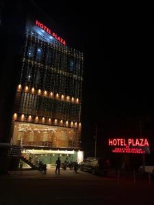 a hotel with a sign on top of it at night at Hotel Plaza Airport Zone in Shamshabad