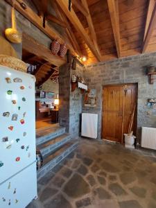 a living room with a refrigerator and a stone wall at Το σπίτι στο χωριό in Kipoi