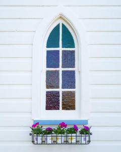 a window with pink flowers in a window box at St Aidan's - Converted Church in Mudgee
