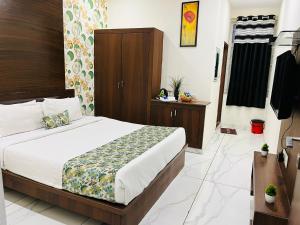 a bedroom with a bed with a wooden headboard at Hotel Plaza Airport Zone in Shamshabad