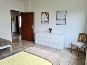 a bedroom with a bed and a dresser and a chair at Work & Stay in Wermelskirchen in Wermelskirchen