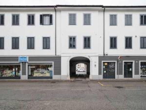 un grande edificio bianco con un arco in una strada di Appartamento Rubino a Gorizia