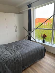 a bedroom with a bed and a large window at City Apartment Dæmningen Vejle in Vejle