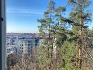 a view of a city with trees and a building at Scenic apartment close to nature in Helsinki in Helsinki