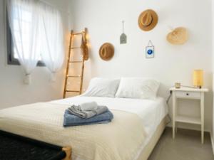 1 dormitorio con 1 cama con toallas en Roberta's Apt Flea Market/Patio/ By the beach en Tel Aviv