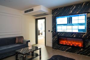 a living room with a fireplace and a tv at Flora Ordu Hotel Apart Suite in Ordu