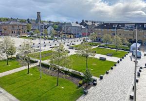 a park with benches and trees in a city at The Flat In The Square in Helensburgh