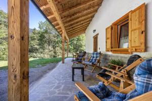 un porche de una casa con sillas y mesa en Baita Cisina, 