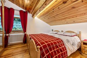 1 dormitorio con cama y techo de madera en Baita Cisina, 