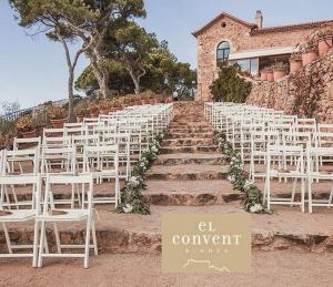 a row of white chairs sitting on the steps of a wedding at Apartament 'Es Botànic' in Blanes