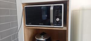a microwave oven sitting on a shelf in a kitchen at Hamdeok Pool Villa Ferrari in Jeju