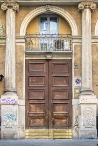 a large wooden door on a building with a balcony at JOIVY Modern and Spacious family flat in Milan