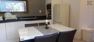 a kitchen with a table with a vase of flowers on it at Hamdeok Pool Villa Ferrari in Jeju