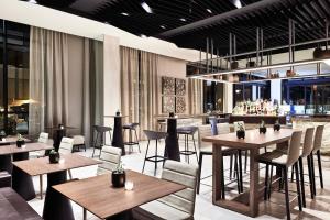 a restaurant with tables and chairs and a bar at AC Hotel by Marriott Missoula Downtown in Missoula