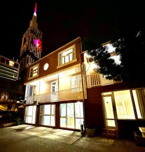 a building with lit up windows and a building with a tower at Hotel Old Boulvared in Batumi