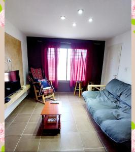 ein Wohnzimmer mit einem blauen Sofa und einem Tisch in der Unterkunft Villa Emoción in Chilecito