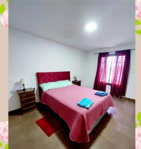1 dormitorio con 1 cama grande con manta roja en Villa Emoción in 
