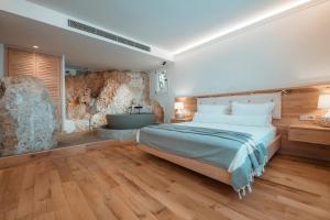 a bedroom with a large bed and a stone wall at Hotel Unique-Boutique Class - Adults Only in Fethiye +37 photos