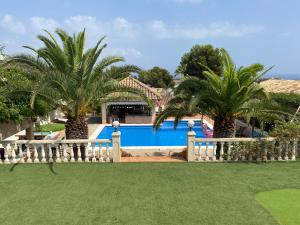 a pool with two palm trees in a yard at Villa Santa Lavinia in Palma de Mallorca