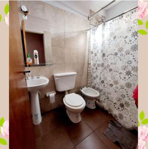 a bathroom with a white toilet and a sink at Villa Emoción in Chilecito