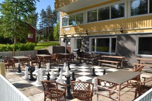 een gigantisch schaakbord op een patio met tafels en stoelen bij Hostelli Kuninkaankartano in Kuninkaanlähde