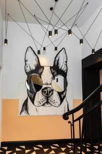 ein Gemälde eines Hundes mit Sonnenbrille an der Wand in der Unterkunft Hotel AVAlex in Berlin