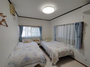 um quarto com 2 camas e uma janela em 幽舍の庭 em Izumi-Sano