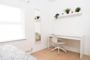 1 dormitorio con escritorio, silla y espejo en Super Modern 2BD Central Home en Belfast