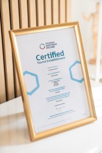 un signo de certificado enmarcado sentado en una mesa en Super Modern 2BD Central Home, en Belfast
