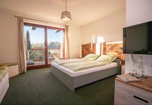 a bedroom with a bed and a flat screen tv at Harz BnB Werkmeister in Sankt Andreasberg