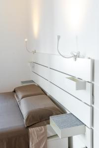 a bed in a room with a white wall at Casa vacanze frate Elia - A 50 mt dalla Basilica di San Francesco in Assisi +44 photos